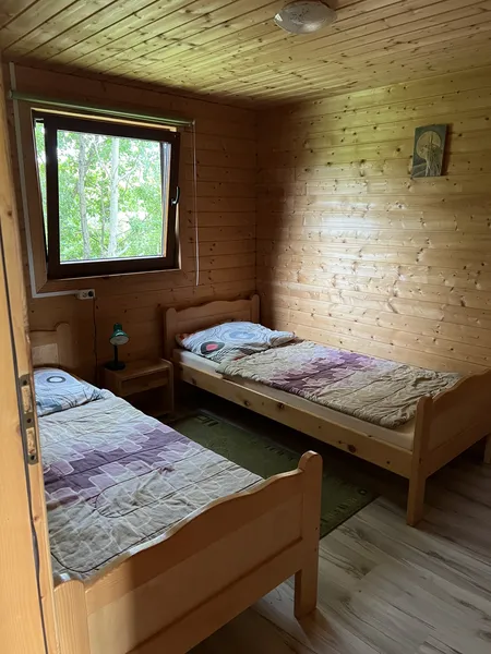 druga sypialnia z dwoma łóżkami pojedynczymi ciepło oświetlona naturalnym światłem