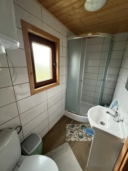 czysta łazienka z toaletą, umywalką, prysznicem i lustrem