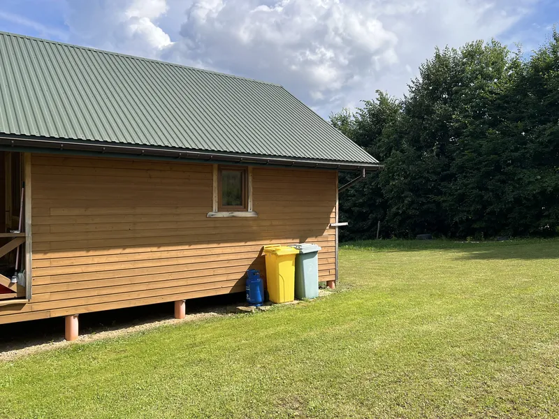 przytulny drewniany domek z dużą przestrzenią zieleni obok